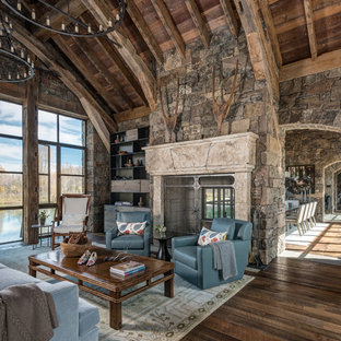 Large mountain style open concept dark wood floor family room photo in Jackson with a two-sided fireplace, a stone fireplace, no tv and beige walls