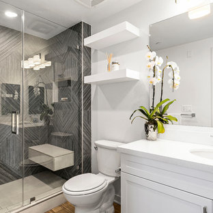 Новый формат декора квартиры: ванная комната среднего размера в стиле современная классика с серой плиткой, керамогранитной плиткой, белыми стенами, фасадами в стиле шейкер, белыми фасадами, душем в нише, душевой кабиной, врезной раковиной, коричневым полом, душем с распашными дверями и белой столешницей