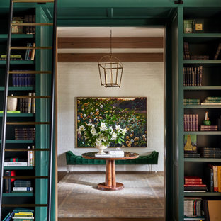 Inredning av ett klassiskt stort arbetsrum, med ett bibliotek, gröna väggar, mellanmörkt trägolv, en standard öppen spis, ett fristående skrivbord och brunt golv