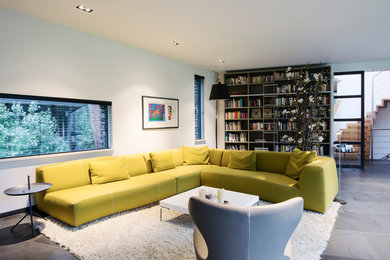 Example of a large trendy open concept ceramic tile living room design in Amsterdam with white walls and a concealed tv