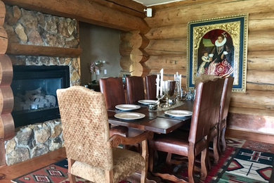 Mid-sized mountain style medium tone wood floor and brown floor dining room photo in Calgary with brown walls, a standard fireplace and a stone fireplace