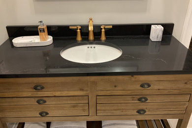 This is an example of a mid-sized contemporary master bathroom in Indianapolis with engineered quartz benchtops and black benchtops.