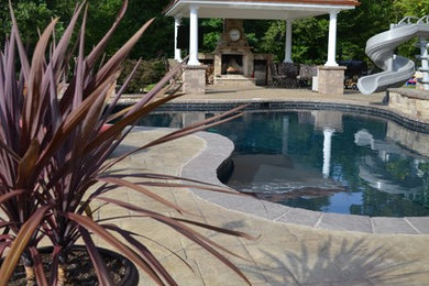 Photo of a mid-sized transitional backyard patio in DC Metro with a fire feature, stamped concrete and a gazebo/cabana.