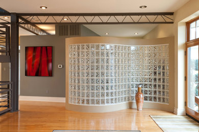 Inspiration for a mid-sized contemporary light wood floor and brown floor entryway remodel in St Louis with beige walls and a glass front door