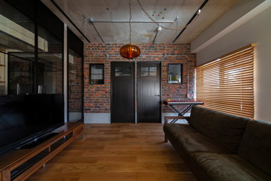 大阪にあるインダストリアルスタイルのおしゃれなLDK (マルチカラーの壁、無垢フローリング、暖炉なし、据え置き型テレビ、茶色い床、表し梁、レンガ壁) の写真