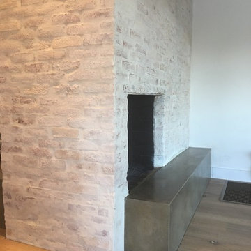Concrete hearth white washed brick fireplace surround