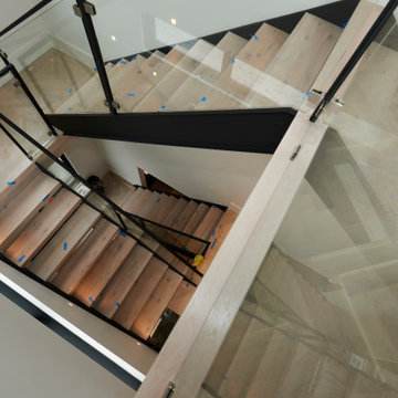 Architectural Staircase with Glass Balustrade and Light Wood Treads