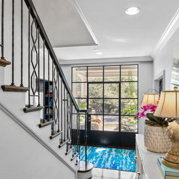 Stylish Foyer with Modern Glass Door and Bold Decorative Accents