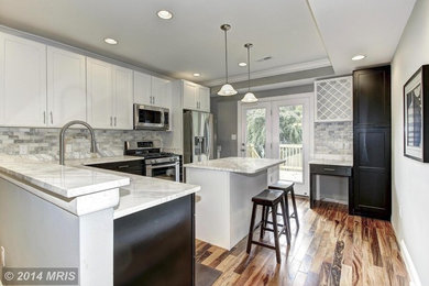 Mid-sized minimalist l-shaped light wood floor eat-in kitchen photo in DC Metro with an undermount sink, shaker cabinets, black cabinets, marble countertops, gray backsplash, ceramic backsplash, stainless steel appliances and an island