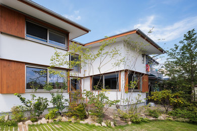 Diseño de fachada de casa blanca y gris escandinava de tamaño medio de dos plantas con revestimiento de estuco, tejado a dos aguas, tejado de metal y panel y listón