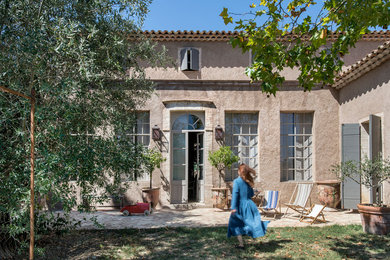 Idées déco pour une façade de maison beige campagne de taille moyenne et à un étage.