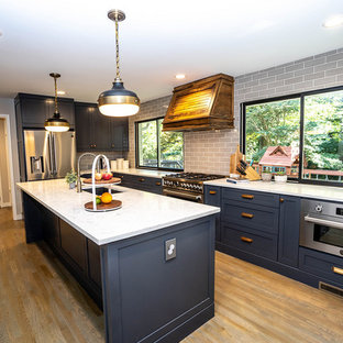 Идея дизайна: п-образная кухня среднего размера в стиле ретро с кладовкой, одинарной раковиной, фасадами в стиле шейкер, синими фасадами, столешницей из кварцевого композита, серым фартуком, фартуком из плитки кабанчик, техникой из нержавеющей стали, паркетным полом среднего тона, островом, коричневым полом и белой столешницей