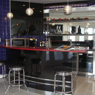 エドモントンの中サイズのトランジショナルスタイルのおしゃれな着席型バー (ドロップインシンク、フラットパネル扉のキャビネット、黒いキャビネット、人工大理石カウンター、ミラータイルのキッチンパネル、磁器タイルの床、青いキッチンパネル、ベージュの床、赤いキッチンカウンター) の写真