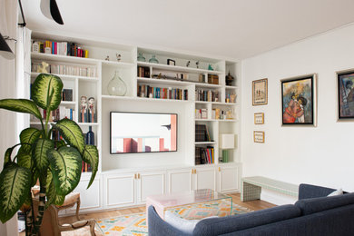 Idées déco pour une grande salle de séjour classique ouverte avec une bibliothèque ou un coin lecture, un mur blanc, parquet clair, aucune cheminée, un téléviseur fixé au mur et un sol beige.