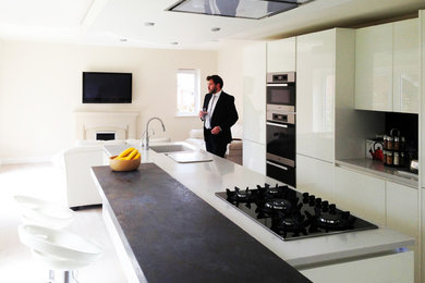 Photo of a mid-sized contemporary kitchen in London with light hardwood floors.
