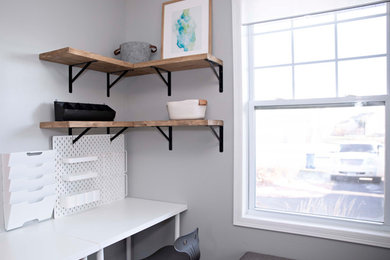Example of a small trendy freestanding desk laminate floor and brown floor home office design in Minneapolis with gray walls
