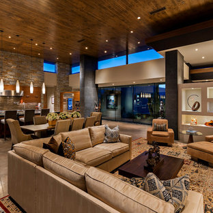 Geräumiges, Offenes Mediterranes Wohnzimmer mit grauer Wandfarbe, Betonboden, Wand-TV und grauem Boden in Phoenix