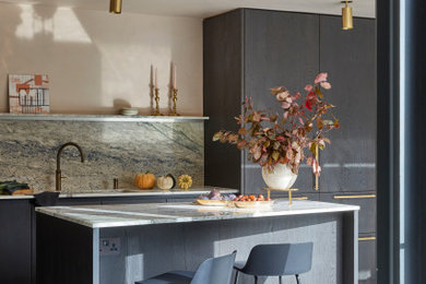 Large modern grey and pink l-shaped kitchen/diner in London with an integrated sink, flat-panel cabinets, black cabinets, marble worktops, multi-coloured splashback, stone slab splashback, terrazzo flooring, an island, grey floors and multicoloured worktops.