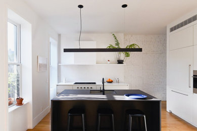 Inspiration for a small scandinavian u-shaped light wood floor and beige floor eat-in kitchen remodel in New York with a single-bowl sink, flat-panel cabinets, white cabinets, quartz countertops, white backsplash, quartz backsplash, paneled appliances, an island and white countertops