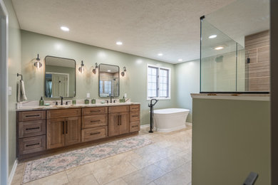 Inspiration for a large transitional master brown tile and porcelain tile vinyl floor, beige floor and double-sink bathroom remodel in Cleveland with flat-panel cabinets, medium tone wood cabinets, a two-piece toilet, an undermount sink, quartz countertops, a hinged shower door, white countertops, a niche and a built-in vanity