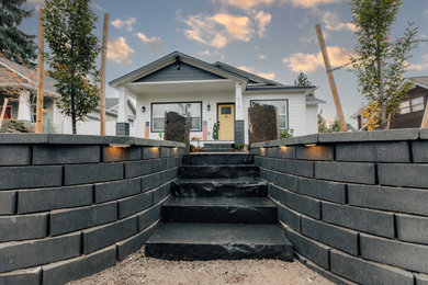 This is an example of a small contemporary full sun front yard concrete paver and stone fence landscaping in Other.