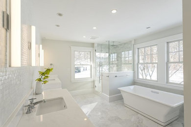 Example of a large transitional master gray tile and glass sheet porcelain tile and gray floor bathroom design in Manchester with white cabinets, white walls, an undermount sink, a hinged shower door, white countertops and recessed-panel cabinets