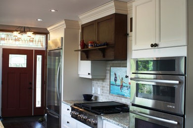 Inspiration for a mid-sized transitional galley dark wood floor open concept kitchen remodel in Toronto with granite countertops, stone tile backsplash, stainless steel appliances, recessed-panel cabinets, beige backsplash, an undermount sink and white cabinets