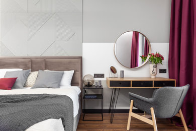 Ejemplo de dormitorio principal y gris y blanco minimalista pequeño sin chimenea con paredes grises, suelo de madera oscura, suelo marrón, panelado y con escritorio
