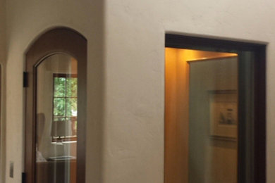 Inspiration for a mid-sized southwestern medium tone wood floor hallway remodel in Houston with beige walls