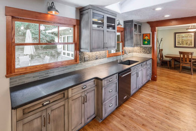 Eat-in kitchen - mid-sized rustic single-wall medium tone wood floor and brown floor eat-in kitchen idea in Portland with an undermount sink, shaker cabinets, gray cabinets, soapstone countertops, stainless steel appliances, an island and gray countertops