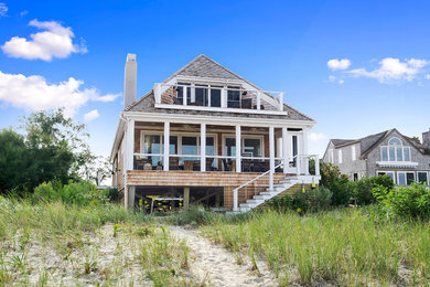Coastal brown two-story wood exterior home idea in Other with a hip roof