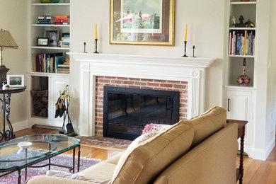 Mid-sized traditional open concept living room in New York with yellow walls, medium hardwood floors, a standard fireplace and a brick fireplace surround.