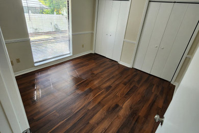 Bedroom - mid-sized craftsman guest laminate floor and brown floor bedroom idea in Tampa with white walls