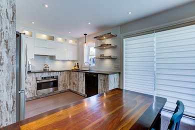 Eat-in kitchen - small rustic u-shaped porcelain tile eat-in kitchen idea in Montreal with an undermount sink, flat-panel cabinets, white cabinets, quartzite countertops, white backsplash, ceramic backsplash and stainless steel appliances