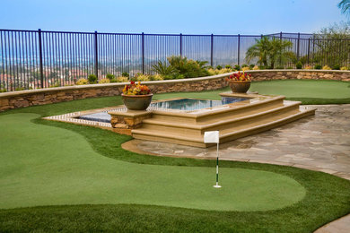 Photo of a large traditional backyard full sun garden in Orange County with a water feature and natural stone pavers.