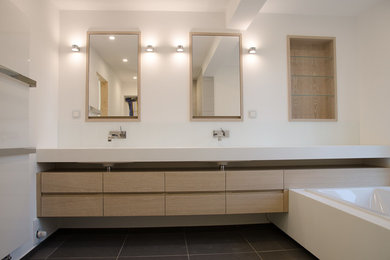 Mittelgroßes Modernes Badezimmer mit flächenbündigen Schrankfronten, hellen Holzschränken, Fliesen aus Glasscheiben, weißer Wandfarbe, Trogwaschbecken und Mineralwerkstoff-Waschtisch in Düsseldorf