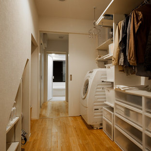 Inspiration for a modern utility room in Kyoto with open cabinets, white cabinets, white walls, medium hardwood flooring, brown floors and an integrated washer and dryer.