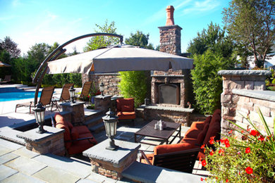 Inspiration for a transitional backyard stamped concrete patio remodel in New York with a fire pit and no cover