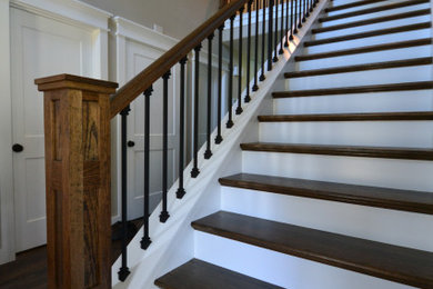 ポートランドにあるラグジュアリーな広いトラディショナルスタイルのおしゃれな直階段 (フローリングの蹴込み板、木材の手すり) の写真