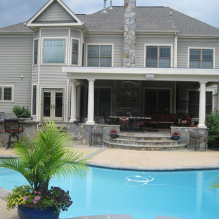 Exempel på en mellanstor klassisk anpassad träningspool på baksidan av huset, med granitkomposit