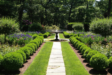 Photo of a traditional backyard formal garden in Bridgeport with a water feature and natural stone pavers.