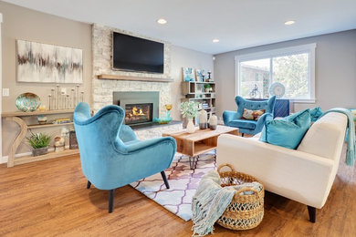 Transitional medium tone wood floor and brown floor living room photo in Seattle with beige walls, a standard fireplace, a metal fireplace and a wall-mounted tv