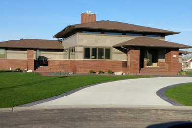 Large arts and crafts brown two-story mixed siding house exterior photo in Orange County with a clipped gable roof and a shingle roof