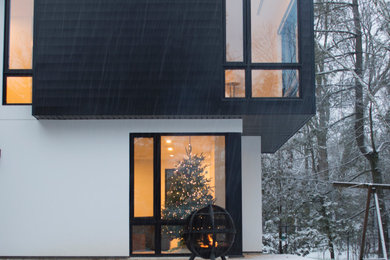 Example of a large trendy white split-level stucco house exterior design