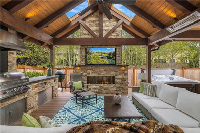Mid-sized mountain style backyard ground level outdoor kitchen deck photo in Seattle with a roof extension