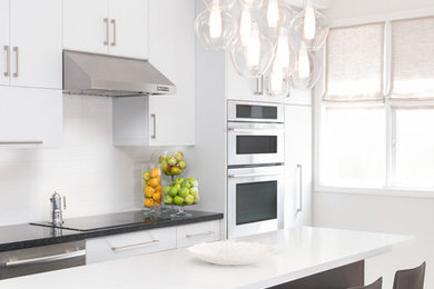 Kitchen - small transitional single-wall medium tone wood floor and brown floor kitchen idea in Toronto with a double-bowl sink, flat-panel cabinets, white cabinets, quartz countertops, white backsplash, porcelain backsplash, stainless steel appliances and an island