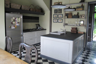 Ispirazione per una grande cucina parallela country con lavello stile country, ante a filo, ante beige, top in marmo, paraspruzzi nero, elettrodomestici in acciaio inossidabile, pavimento in cementine, penisola e pavimento nero