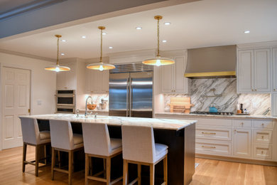 Large elegant medium tone wood floor and brown floor open concept kitchen photo in San Francisco with an undermount sink, recessed-panel cabinets, white cabinets, marble countertops, multicolored backsplash, marble backsplash, stainless steel appliances, an island and multicolored countertops