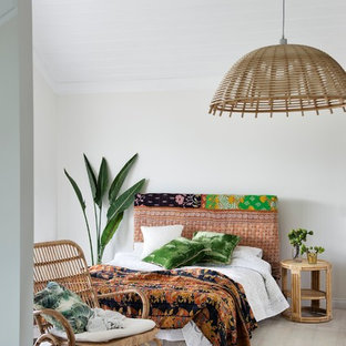 Esempio di una camera degli ospiti tropicale con pareti bianche, parquet chiaro e nessun camino