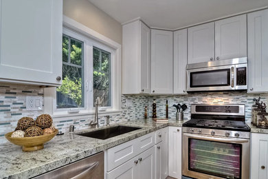 Inspiration for a mid-sized transitional l-shaped medium tone wood floor open concept kitchen remodel in Boise with an undermount sink, recessed-panel cabinets, white cabinets, granite countertops, gray backsplash, matchstick tile backsplash, stainless steel appliances and an island